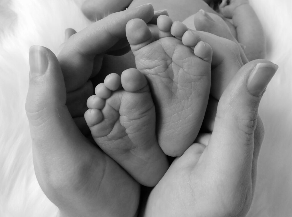 mother holding baby feet